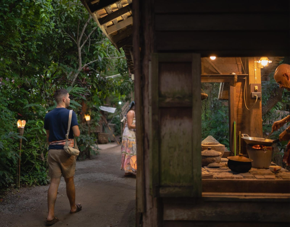 A person walking on a path with a wood building and trees

AI-generated content may be incorrect.